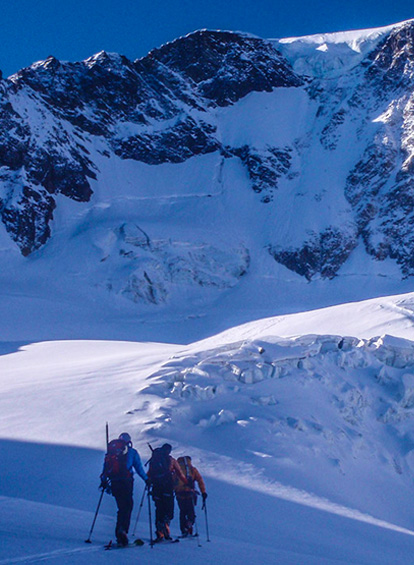 People skinning up a mountain on skis